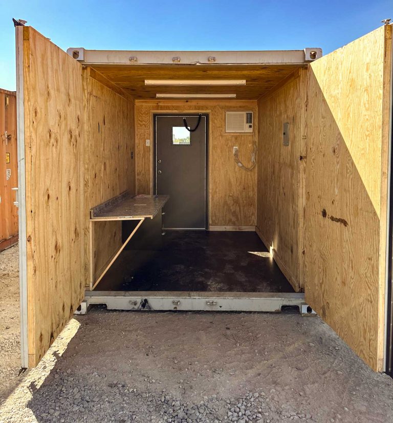 container with wood panel walls, a/c, desk and man door